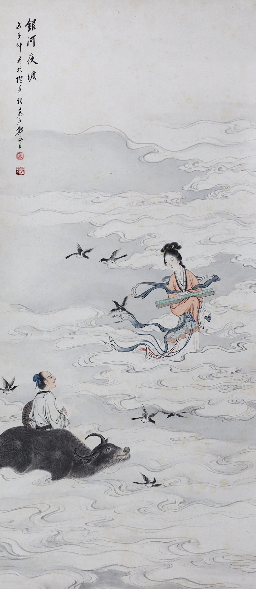 A Chinese scroll painting on paper of a female immortal and a male immortal riding a Buffalo amid clouds and birds, early 20th century, image 77cm x 34.5cm